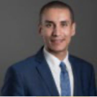 Man in a blue suit and tie with a neutral background